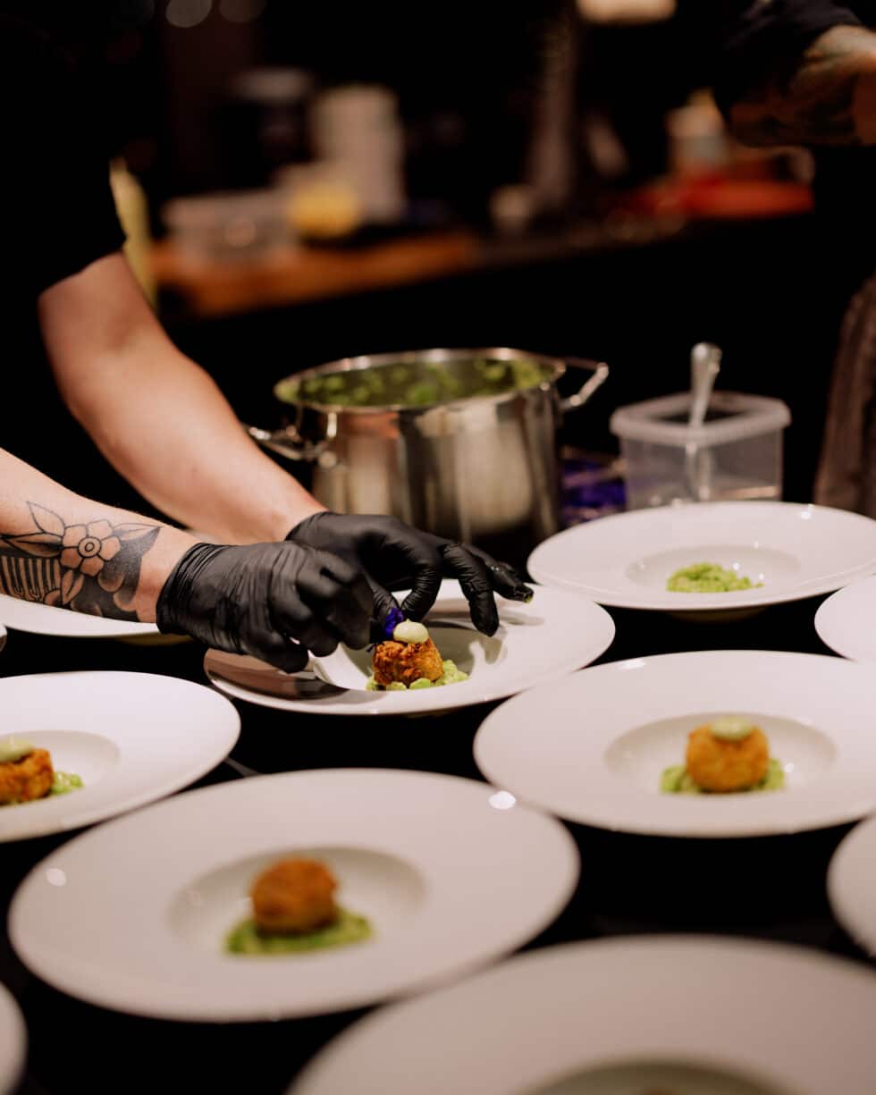 a group of people in black gloves serving food